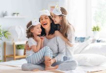 A happy mother and her two daughters after waking up from a comfortable night of sleeping on their new hybrid mattress.